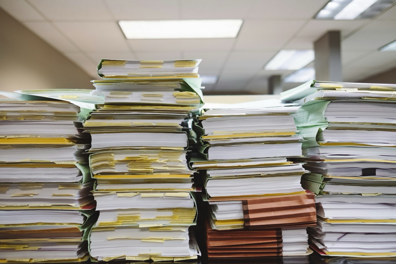 Several piles of paper on a table.